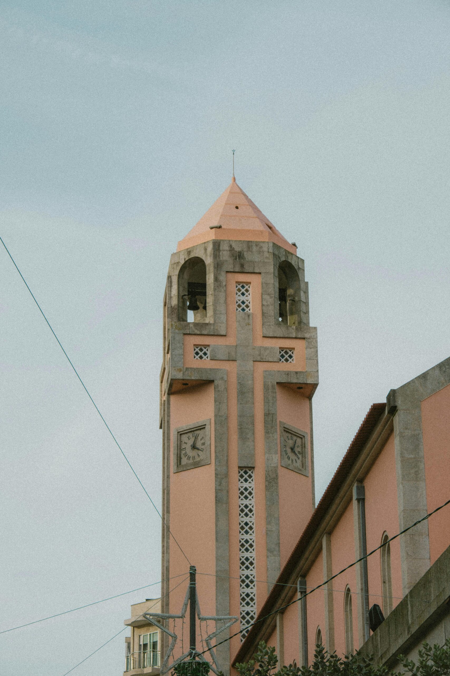 A serene view of a church tower in Póvoa de Varzim, Portugal, showcasing unique architecture.