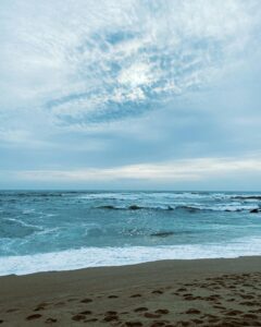 Relax at Povoa de Varzim's beautiful beach with calming waves and an expansive blue sky.